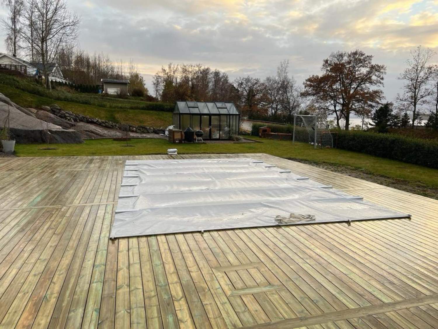 Stort trädäck med pool byggt av Arkipel i kvällsljus
