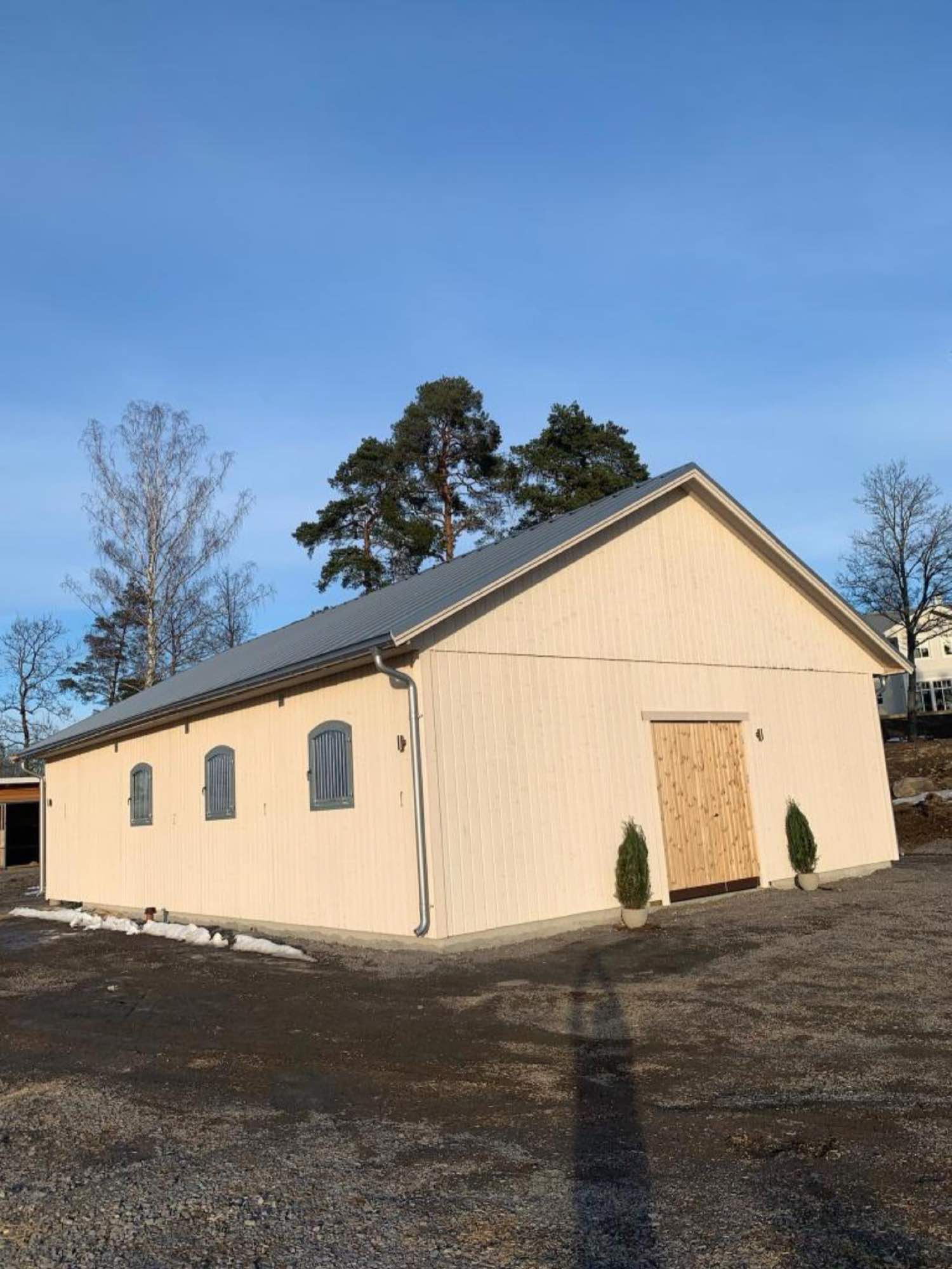 Nybyggt stall med träfasad och stalldörrar byggt av Arkipel