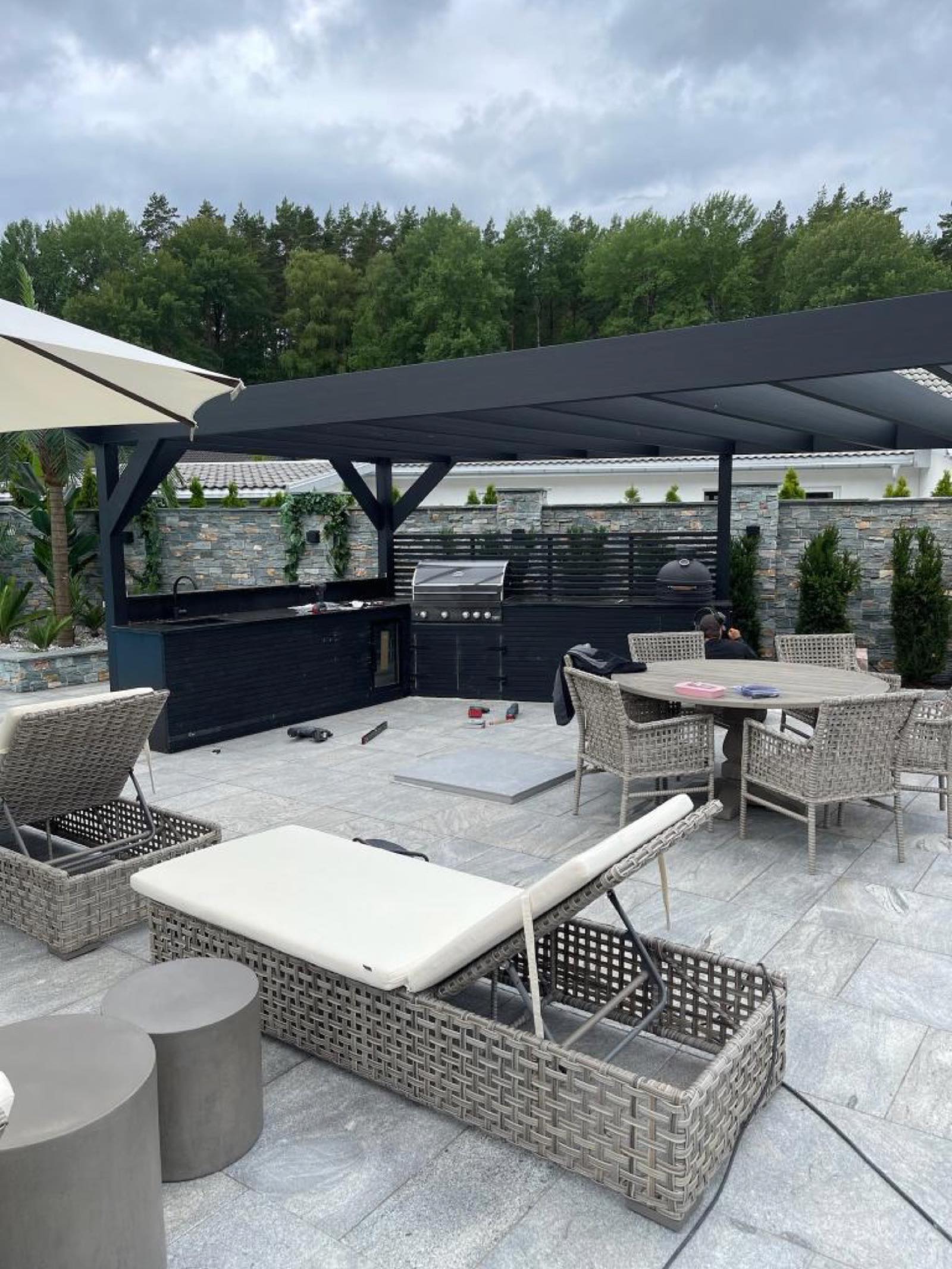 Utekök och lounge under pergola vid pool